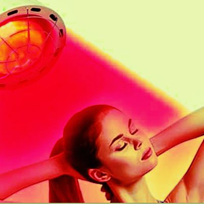 Red light lamp device focused on woman's hair during Red Therapy for Hair at Studio Joi