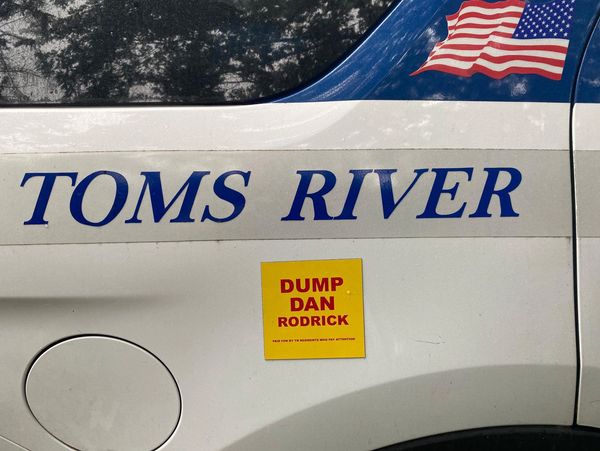 A vehicle with 'TOMS RIVER' and a 'DUMP DAN RODRICK' sticker.