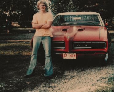 Deke Standing in front of a Classic Car.