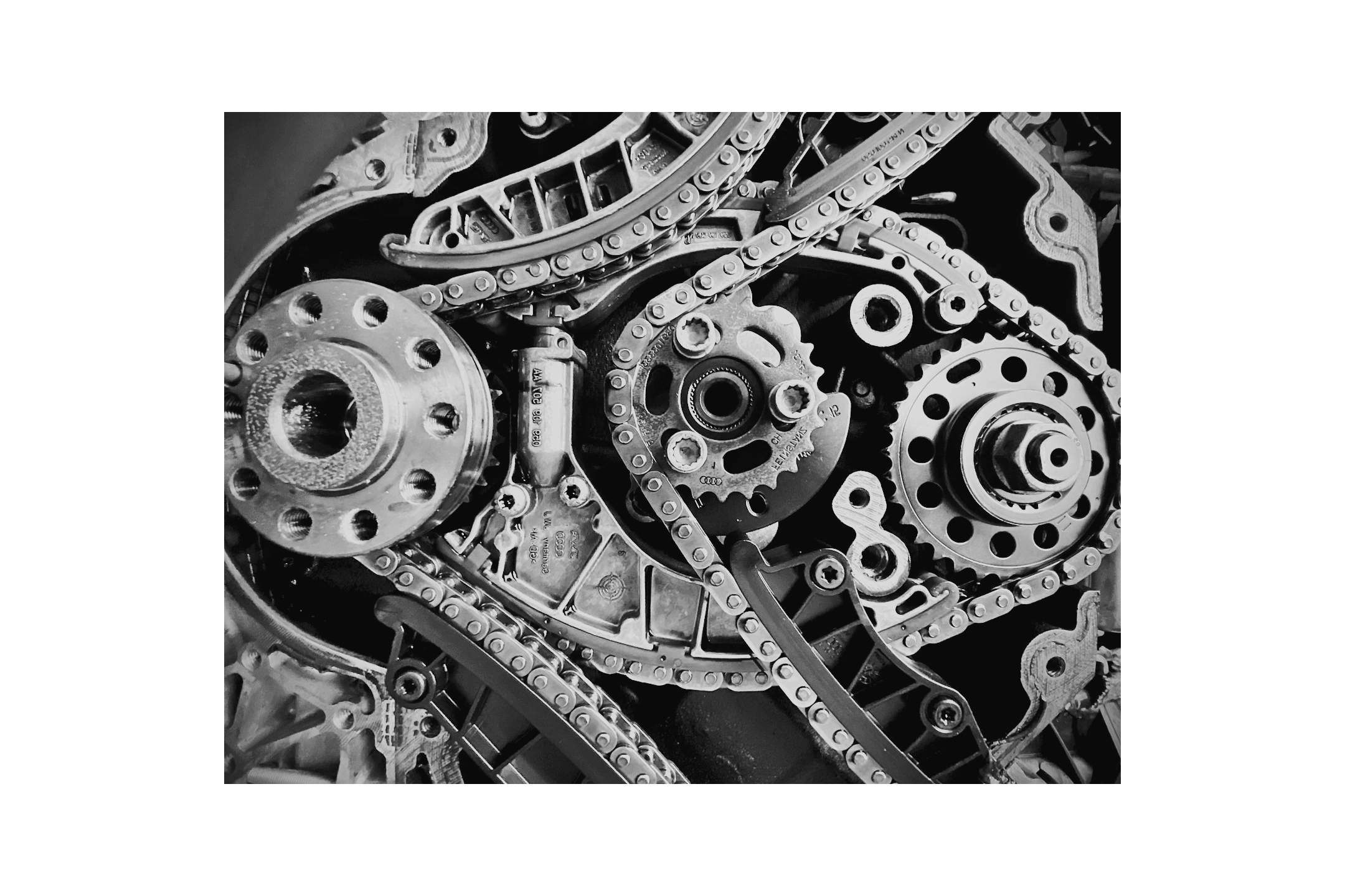 Close-up of shiny metal pulleys and belts in a car engine.