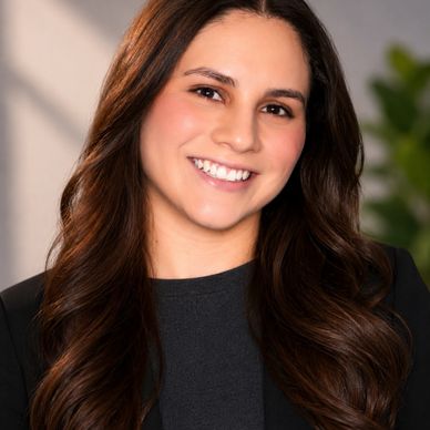 Smiling woman with long brown hair in professional attire.