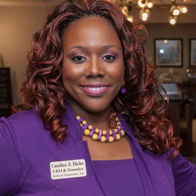 Professional woman wearing a purple outfit and name tag, smiling.