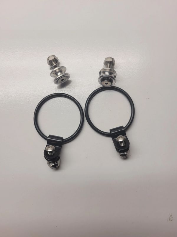 Two black hose clamps with screws on white background.