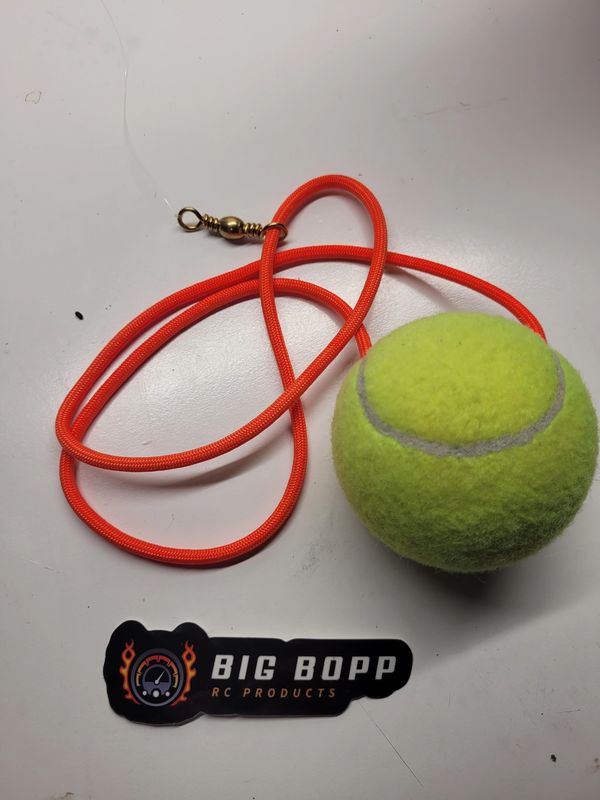 Tennis ball attached to an orange cord with a swivel clip.