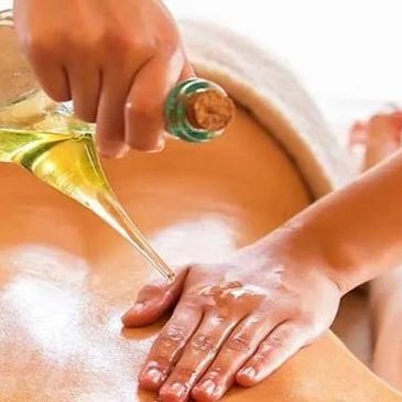 Pouring oil on a back for massage therapy.