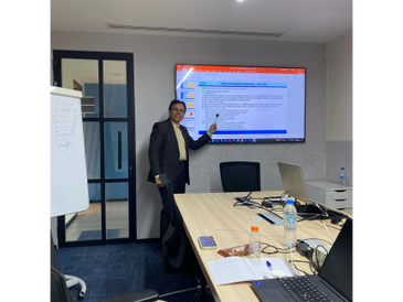 Man presenting investment strategies in a modern conference room.