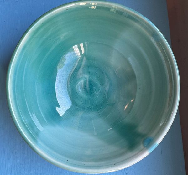 A wheelthrown bowl glazed sky blue.