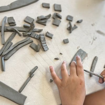 A student cuts small rectangle pieces of clay