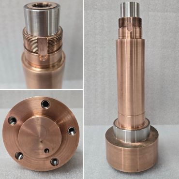 Copper and steel precision-machined component with threaded sections.