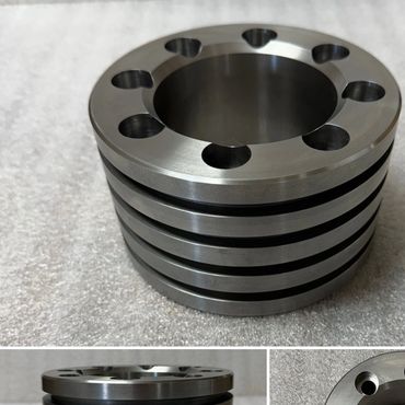 Shiny metal mechanical part with multiple holes and rings.