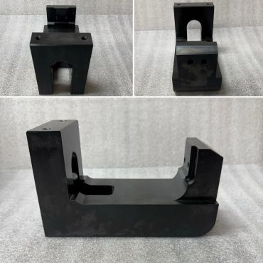 Black industrial metal parts with various shapes and cutouts.
