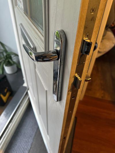 Close-up of a door handle and lock mechanism on a white door.