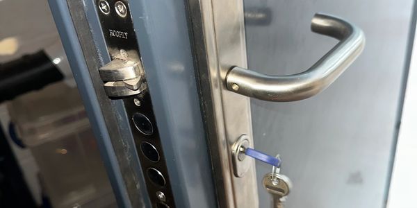 Close-up of a door handle and key inserted in a lock.