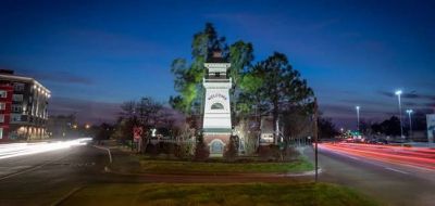 Clock tower at dusk with traffic lights streaking past.