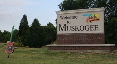 Welcome sign for Muskogee with a guitar sculpture nearby.