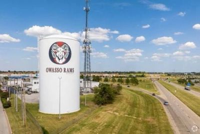 Water tower with Owasso Rams logo by roadside.