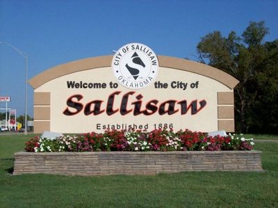 Welcome sign for the City of Sallisaw, Oklahoma, with flowers in front.
