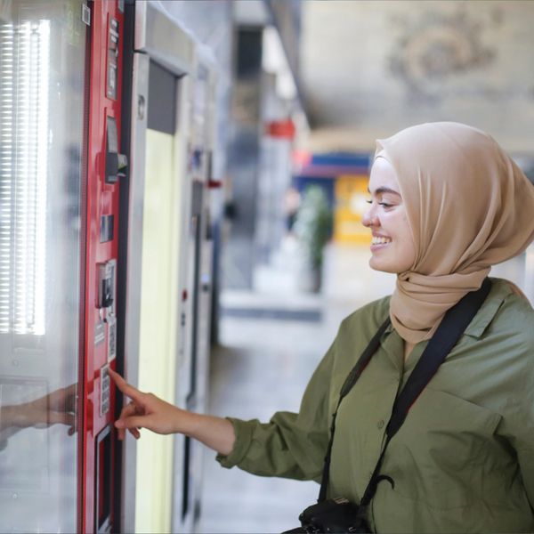 Muslim female using vending services for a beverage