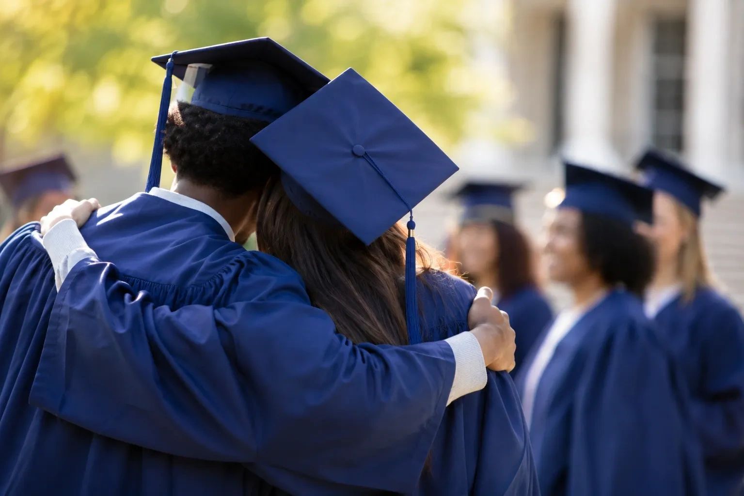 group of graduates hugging 