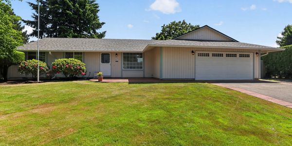 Single-story house with a large garage and well-maintained lawn.