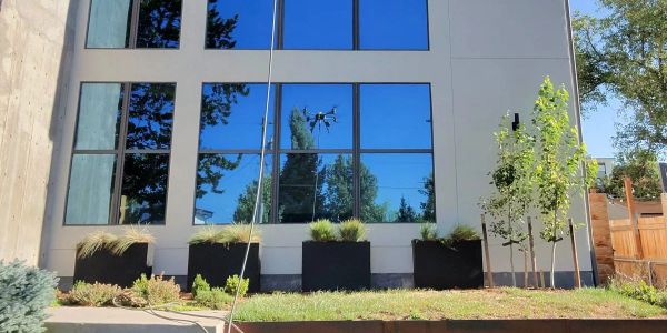 Drone power washing a modern three-story home in Denver