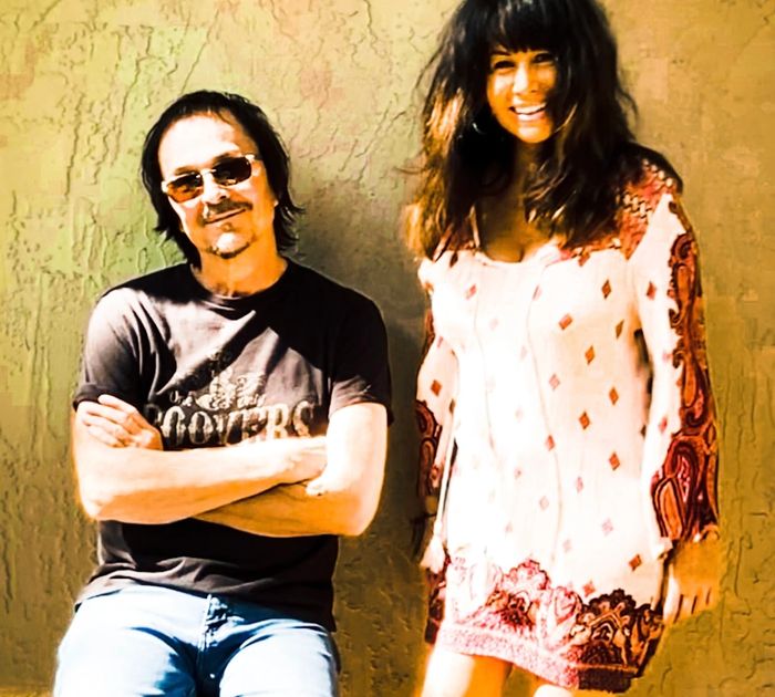 A colorful logo featuring two birds and a guitar with 'The Flying Stones' text.