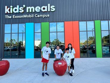 Four kids posing outside a kids' meals eatery at ExxonMobil Campus.