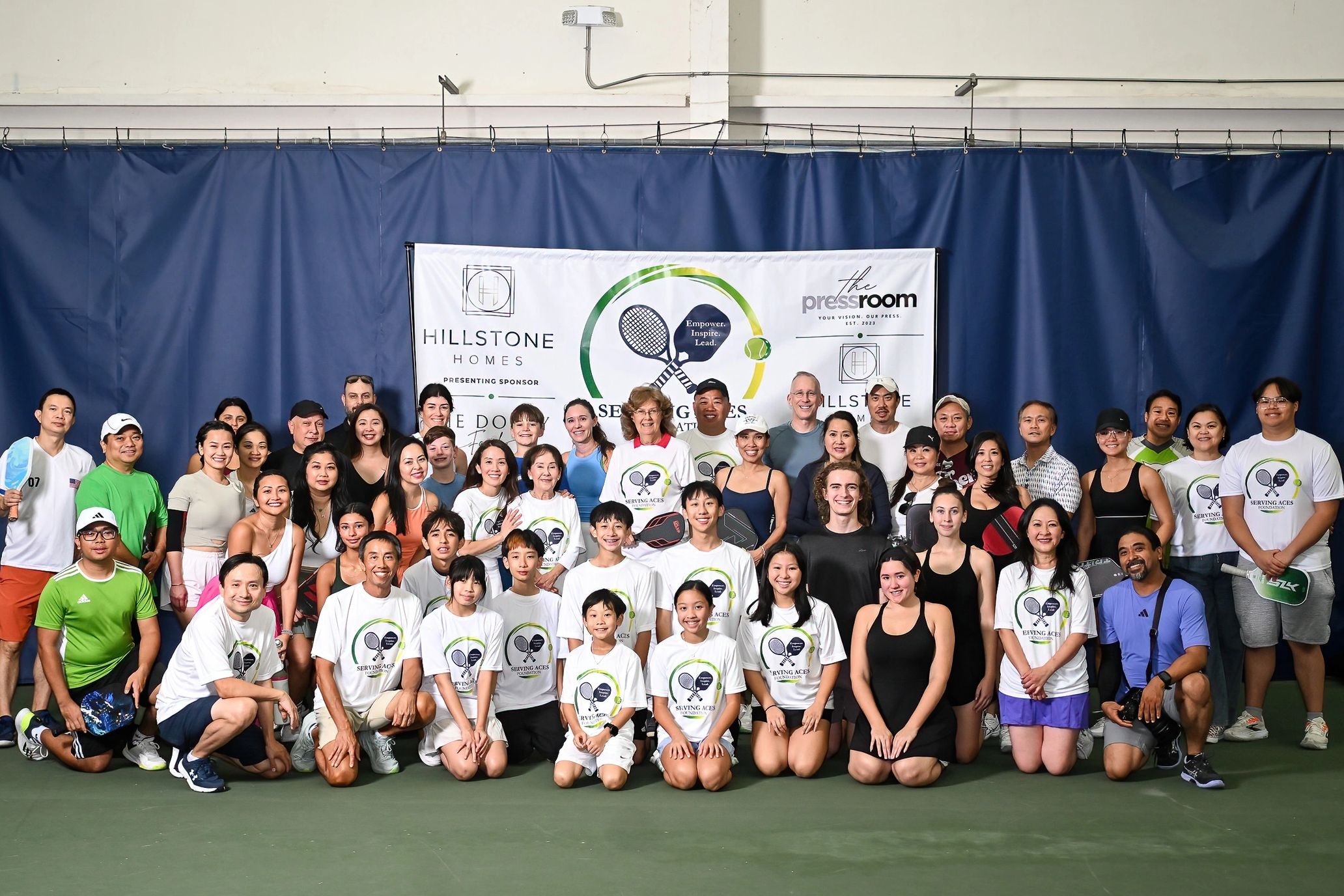 Large group photo at a tennis event.
