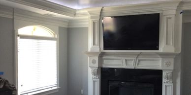 Elegant white fireplace with mounted flat-screen TV in a cozy living room.