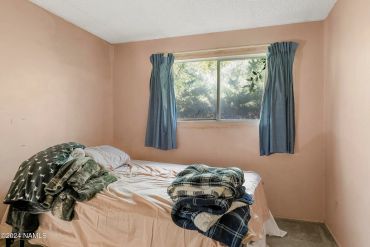 Simple bedroom with a bed and folded blankets.
