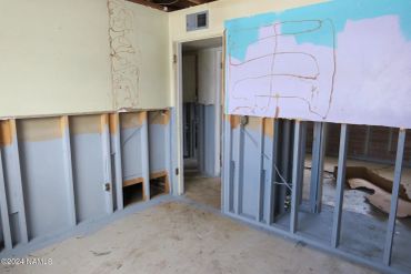 Room under construction with exposed studs and drywall.