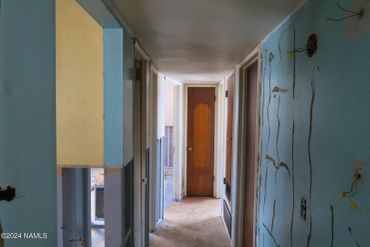 Narrow hallway in an old building with peeling paint.