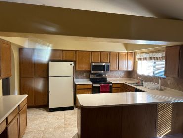 Cozy kitchen with wooden cabinets and beige tiles.