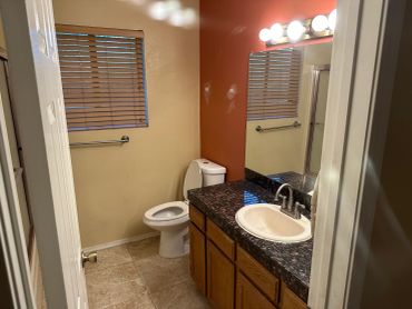 Bathroom with toilet, sink, and mirror.