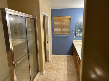 Bathroom with a blue accent wall and glass shower door.