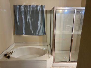 Bathroom with a bathtub and glass shower cubicle.