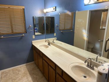 Bathroom with double sink and blue walls.