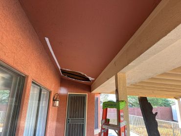 Ceiling damage with a ladder beneath it.