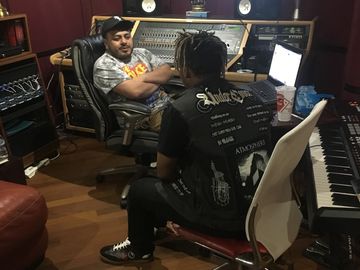 Two men in a music studio working on a project.
