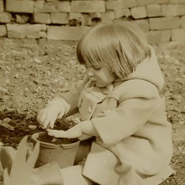 Lucinda at 2 years playing with mud