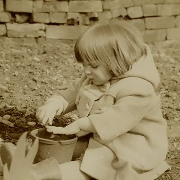 Lucinda at 2 years playing with mud