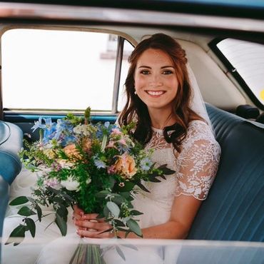 A bride sitting in their wedding car