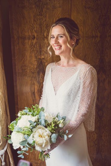 A bride smiling holding flowers