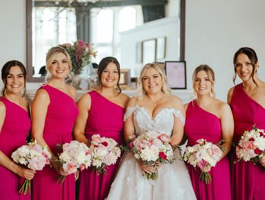 A Bride and her five bridesmaids who are wearing pink
