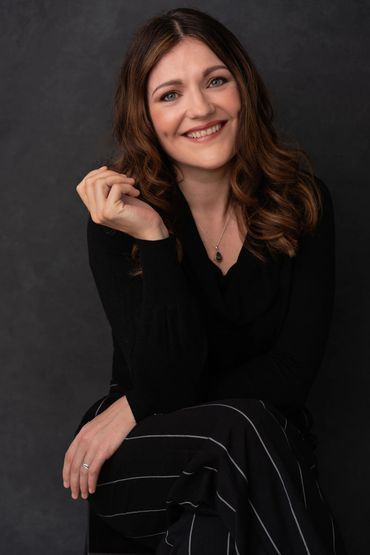 A brown haired lady with her legs crossed