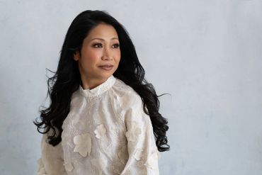 An Asian lady in a white flowery top