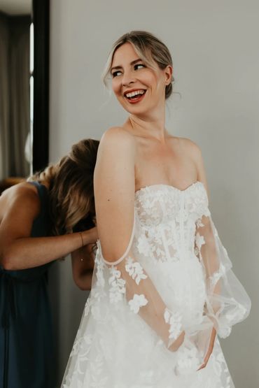 A bride's dress being fastened