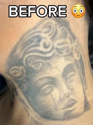 Faded tattoo of a classical-style face on skin before a touch-up.