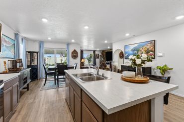 Modern kitchen island with dining area in the background.