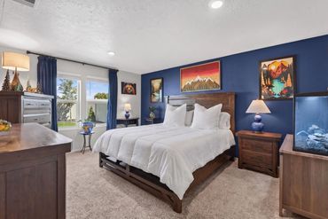 Cozy bedroom with blue walls and wooden furniture.